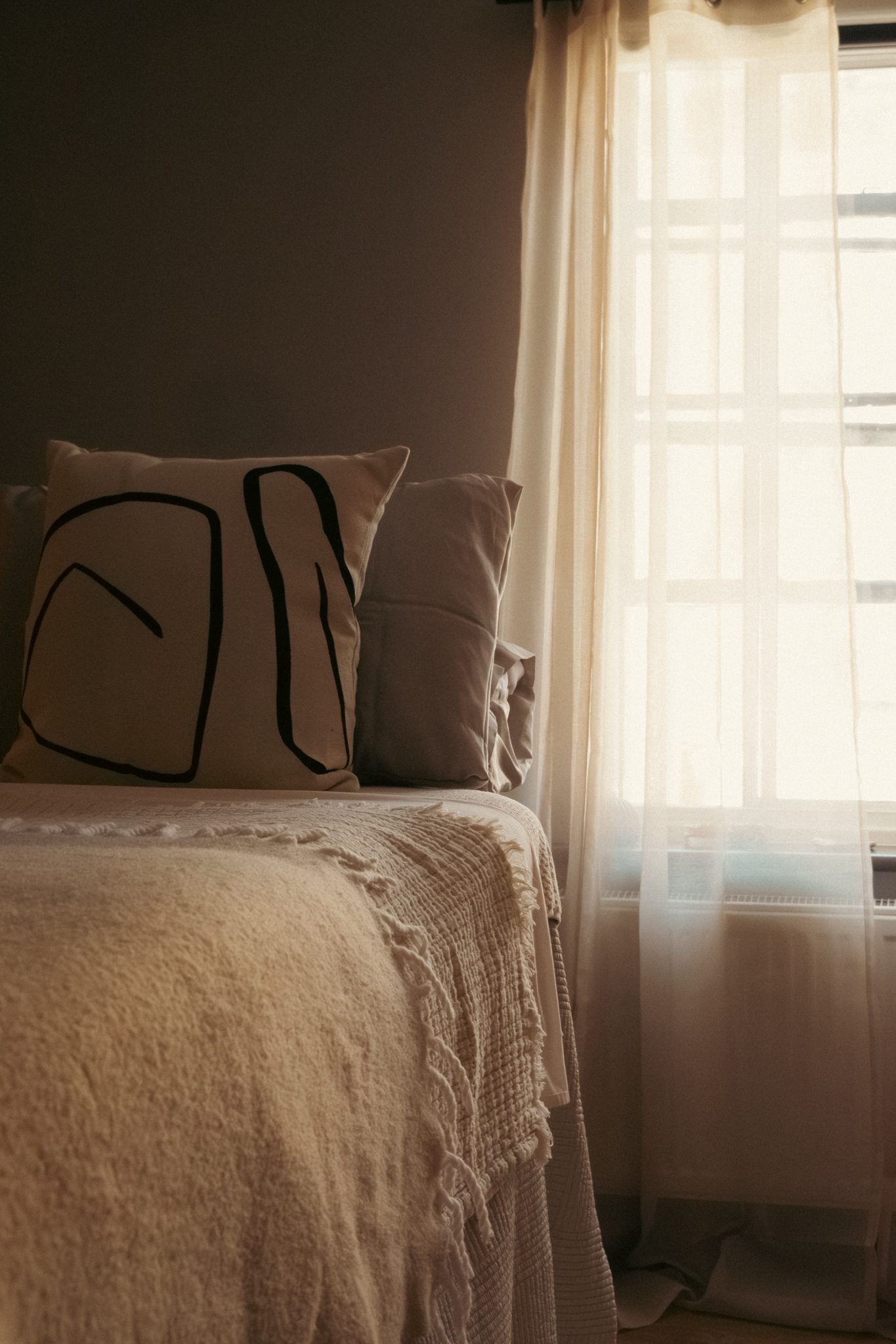 The treatment bed by the sheer-curtained window