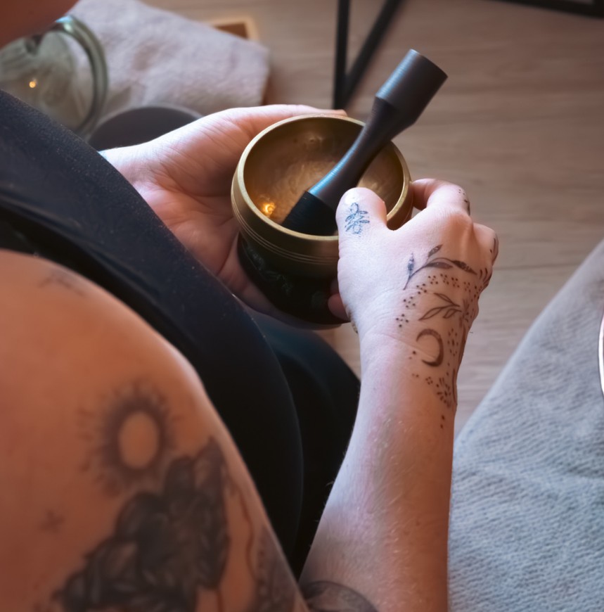 Abbi holding a brass singing bowl and mallet