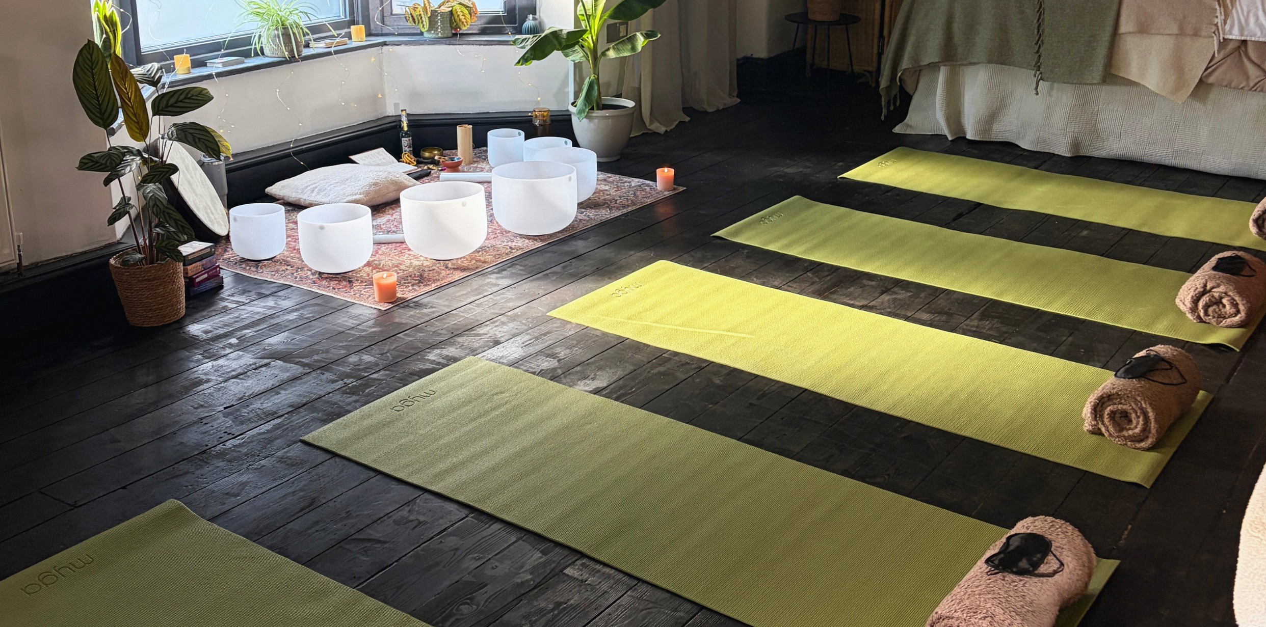 Yoga mats, eye pillows and crystal bowls set out for a sound bath